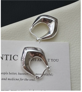 Close-up of S925 sterling silver geometric hoop earrings showing the hallmark stamp