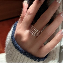 Detail of S925 sterling silver multi-layer line ring worn with white knit sweater