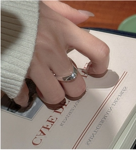 Detail eines minimalistischen S925 Silberrings im Wellendesign für einen eleganten Look