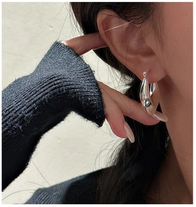 Close-up of minimalist S925 sterling silver hollow shield hoop earring on model ear