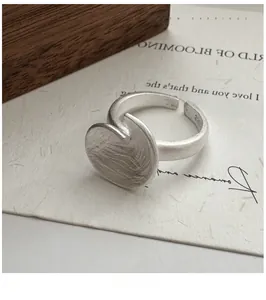 Macro shot of S925 sterling silver ring with matte texture and irregular disc design