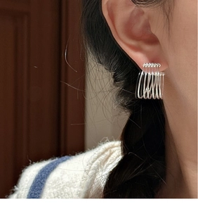 Macro shot of minimalist S925 sterling silver multilayer geometric hoop earrings on ear