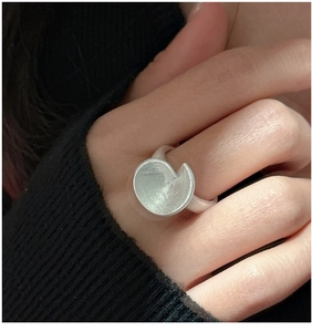Macro shot of minimalist matte silver ring with geometric concave design on hand