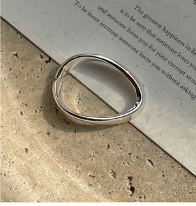 Minimalistisches silbernes ovales Klapparmband auf natürlichem Steinhintergrund