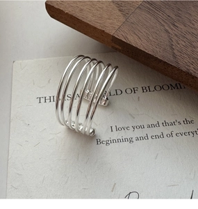 Close-up of a minimalist multi-layer silver ring with five thin lines on artistic card