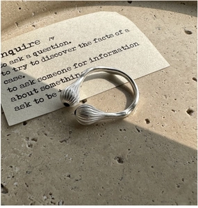 Détail d'une bague en argent S925 mate avec lignes irrégulières et accents d'onyx noir