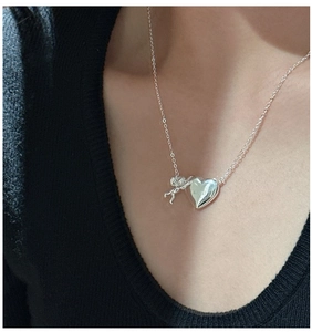 Détail du collier avec pendentif cœur et ange cupidon en argent S925 sur un mannequin