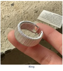 Detail of S925 sterling silver wire-wrapped ring with intricate woven metal textures