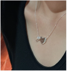 Gros plan d'un pendentif cœur en argent S925 avec gravure HEART et breloque ange cupidon