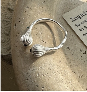 Détail d'une bague en argent S925 avec onyx noir et motif de bourgeons rayés sur pierre