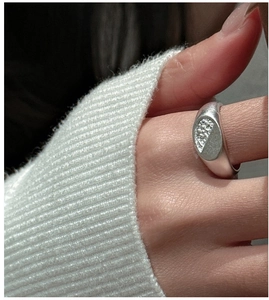 Macro detail of S925 silver ring with micro-pave white stones and matte texture finish
