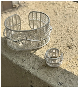 Detail shot of S925 silver mesh ring and cuff set with thorn texture on stone surface