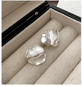 Macro detail of S925 sterling silver earrings with a matte wrinkled petal design