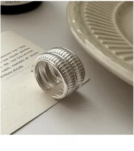 Macro detail of silver layered wide ring with vertical pleats and adjustable band