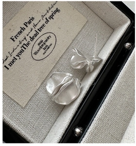 Macro shot of S925 sterling silver matte wrinkled earrings in a luxury jewelry display box