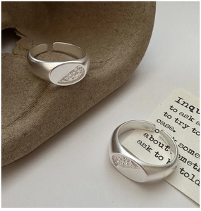 Macro detail of matte silver rings with textured oval design on vintage background