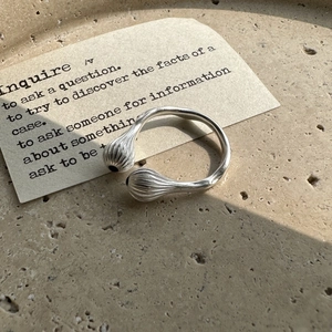 Bague ouverte minimaliste en argent S925 avec extrémités rayées sur un plateau