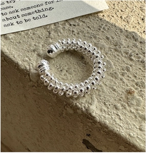 Dettaglio dell'anello in argento S925 con filo di perline e finitura metallica