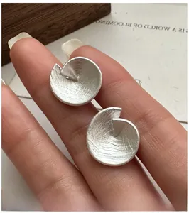 Vue macro de boucles d'oreilles irrégulières en argent S925 avec fini mat