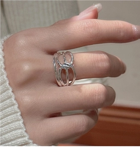 Detail view of S925 sterling silver multilayer twisted knot ring worn on a model's finger