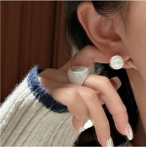 Gros plan sur des boucles d'oreilles et une bague en argent S925 à texture plissée