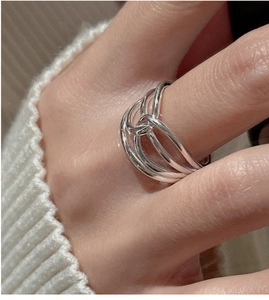 Detailed view of layered S925 sterling silver ring on index finger with sleek metal texture