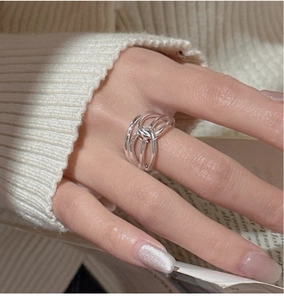 Detail shot of a multilayer silver ring with knot design on a minimalist background