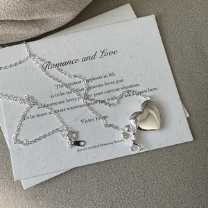 Élégant collier pendentif ange et cœur en argent S925 sur une carte en papier blanc