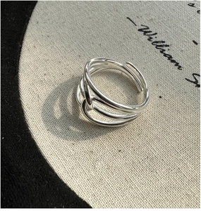 Detailed close-up of S925 sterling silver multilayer ring on a minimalist canvas background
