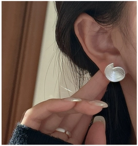 Gros plan sur boucles d'oreilles spirales en argent S925 et bague sur mannequin