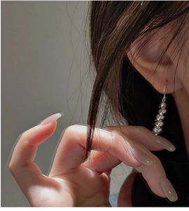 Detailed view of silver heart-shaped drop earrings with a cascading link design