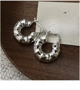 Détail de créoles en argent sterling S925 avec texture ondulée irrégulière et style rétro