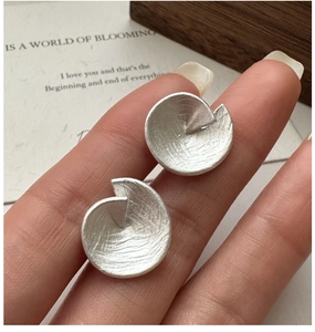 Vue détaillée des boucles d'oreilles en argent avec texture brossée et design spiralé