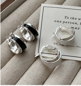 Detailed macro view of S925 silver hoop earrings with black enamel inlay and polished finish