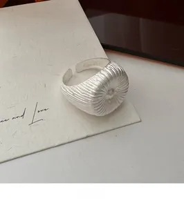 Vue détaillée d'une bague en argent S925 avec textures plissées radiales uniques