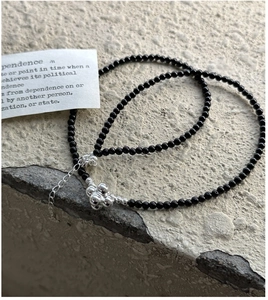 Macro detail of S925 silver beaded necklace with black beads and silver accents