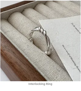 Macro shot of silver knot ring with crossed lines in a wooden linen jewelry box