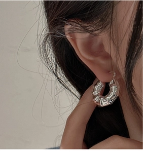 Gros plan sur les créoles en argent S925 avec design bambou, texture torsadée et poli miroir