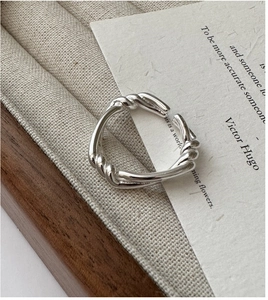 Close-up of S925 sterling silver knotted ring with cross twist design on a display tray