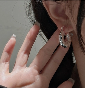 Vue macro d'une boucle d'oreille minimaliste en argent S925 avec design texture bambou