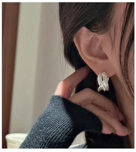 Close-up of S925 sterling silver earrings with unique irregular wrinkled matte texture