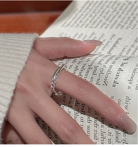 Detailed view of an S925 sterling silver knotted ring on a cozy sweater background