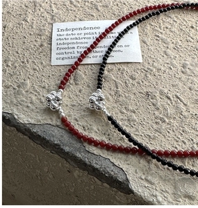 Detail of S925 sterling silver beaded necklace with red and black stones and silver cluster