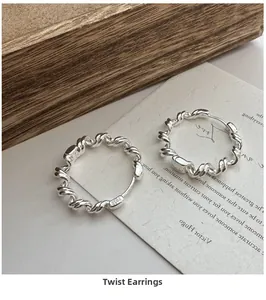 Macro shot of S925 sterling silver twisted hoop earrings with fine braided metal texture