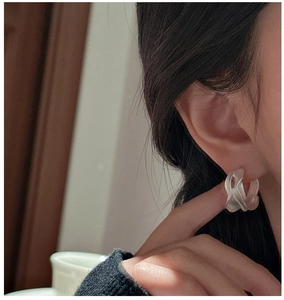Close-up of S925 sterling silver hoop earrings with irregular wavy matte texture