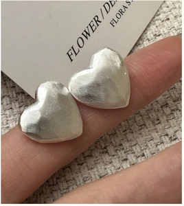 Detailed macro of S925 sterling silver matte heart stud earring with brushed metal texture