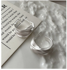 Macro shot of S925 sterling silver earrings with a matte textured irregular twisted design