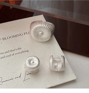 Détails d'une bague et boucles d'oreilles en argent S925 avec texture soleil raffinée
