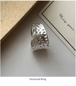 Dettaglio dell'anello in argento S925 con trama in metallo martellato e tre piccoli zirconi