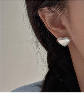 Close-up of S925 sterling silver heart stud earrings with hammered matte texture